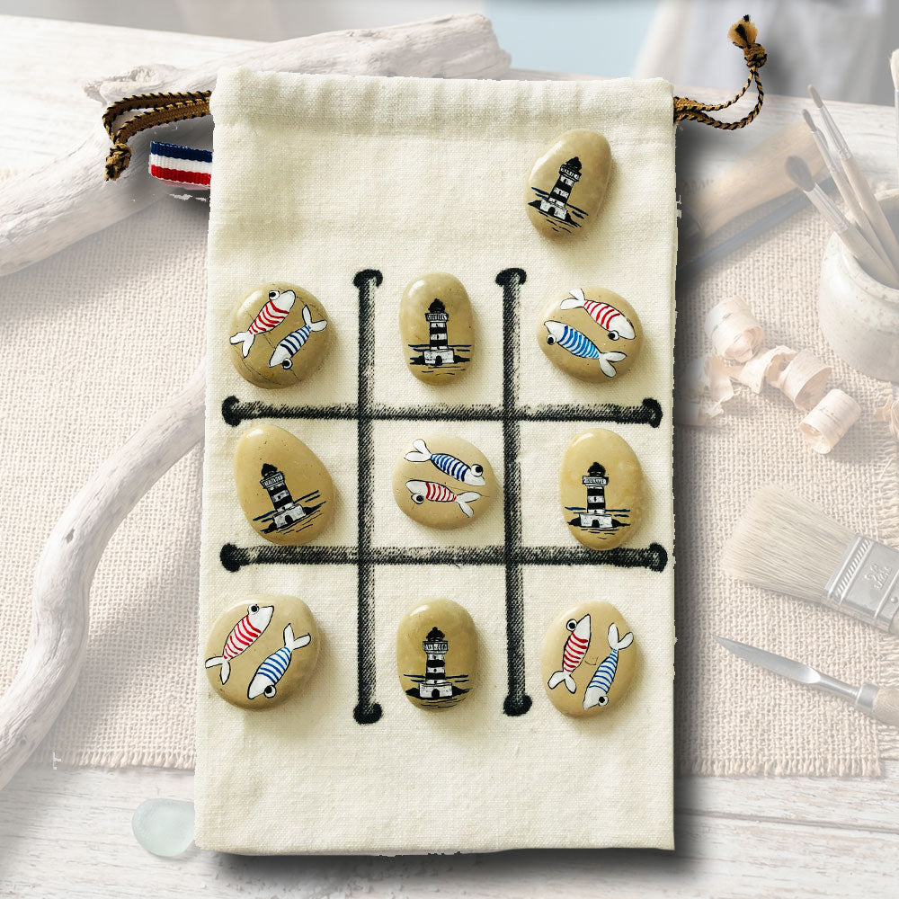 Jeu de morpion artisanal sur galets, motifs poissons à rayures et phares bretons, sachet en toile beige 15x21cm, création L'Atelier du Ressac.