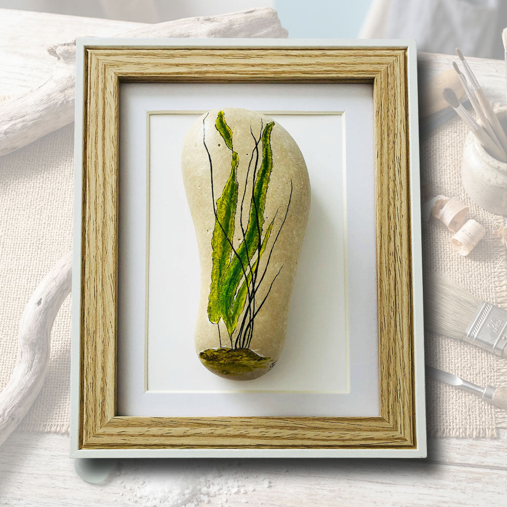 Galet naturel lisse peint à la main avec un motif minimaliste d'algues vertes et lignes noires, cadre coffret bois et blanc 15x21cm, artisanat d'art Auvergne L'Atelier du Ressac.